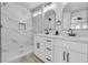 Bathroom featuring a double vanity with modern fixtures and a tiled shower with marble accents at 3137 Sunrise Cove Ave, North Las Vegas, NV 89031