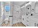 Bright bathroom featuring a dual vanity, toilet, and walk-in shower with marble tile surround at 3137 Sunrise Cove Ave, North Las Vegas, NV 89031