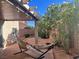 Inviting backyard with a covered patio, cozy hammock, and mature, flowering bushes at 3337 Autumn Veil St, Las Vegas, NV 89129