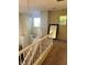 Carpeted hallway with white railings, a hanging light fixture, and natural light at 3337 Autumn Veil St, Las Vegas, NV 89129