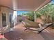 Covered patio with brick flooring, a comfortable hammock, and lush green plants at 3337 Autumn Veil St, Las Vegas, NV 89129