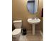 Powder room featuring white toilet and pedestal sink, plus stylish mirror at 3337 Autumn Veil St, Las Vegas, NV 89129