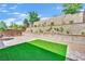 Well manicured backyard features artificial turf, tiered landscaping, and block wall at 343 American Dipper St, Las Vegas, NV 89138