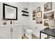 Chic bathroom features a vanity with white countertops and dark fixtures, art and floating shelves at 343 American Dipper St, Las Vegas, NV 89138