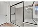 Contemporary bathroom featuring a glass-enclosed shower with gray tile, white door, and modern fixtures at 343 American Dipper St, Las Vegas, NV 89138