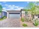 The home features desert landscaping, a gray two-car garage, and stone trim at 343 American Dipper St, Las Vegas, NV 89138