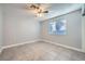 This light gray bedroom features a ceiling fan and window for lots of natural light and tiled floor at 3675 Winner Dr, Las Vegas, NV 89120