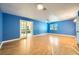 Spacious living room with wood floors, blue walls, a window, and French doors to the kitchen at 3675 Winner Dr, Las Vegas, NV 89120