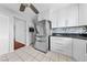 Kitchen featuring stainless steel refrigerator, white cabinets, granite countertops and neutral tile flooring at 4272 E Russell Rd, Las Vegas, NV 89120