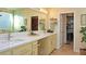 Well-lit bathroom featuring double sinks, granite countertops and an open walk-in closet at 5059 Pensier St, Las Vegas, NV 89135