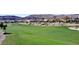 Beautiful golf course featuring vibrant green grass with mountains in the background at 5059 Pensier St, Las Vegas, NV 89135