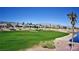 Beautiful golf course view with lush green grass and palm trees in a desert community against a mountain backdrop at 5059 Pensier St, Las Vegas, NV 89135