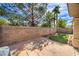 Enclosed backyard features lush artificial grass, rock accents and a brick wall, ideal for outdoor relaxation and entertaining at 5078 Shadow River St, Las Vegas, NV 89148