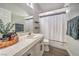 Well-lit bathroom featuring a clean vanity, updated faucet, and a shower with stylish curtain at 5078 Shadow River St, Las Vegas, NV 89148