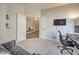 Comfortable bedroom featuring plush gray carpeting and a wall-mounted television at 5078 Shadow River St, Las Vegas, NV 89148