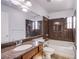 Bright bathroom featuring a sink with dark-wood cabinets, bathtub, toilet and marbled wall at 5186 Bootlegger Ave, Las Vegas, NV 89141