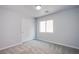 A neutral bedroom features a closet with sliding doors, carpet and a large window at 5186 Bootlegger Ave, Las Vegas, NV 89141