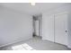 A neutral bedroom features a double closet with sliding doors and new light-grey carpet at 5186 Bootlegger Ave, Las Vegas, NV 89141