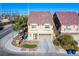 Two-story home features a terracotta-colored tile roof, a lawn and a two-car garage at 5186 Bootlegger Ave, Las Vegas, NV 89141