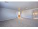 Large carpeted living room with neutral walls, many windows and a glimpse of the bathroom at 5186 Bootlegger Ave, Las Vegas, NV 89141