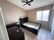 Bedroom featuring tiled floors, neutral walls, a ceiling fan, and a window with backyard views at 5513 Oakwood Ridge St, Las Vegas, NV 89130