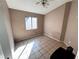 Bedroom featuring tiled floors, neutral walls, a ceiling fan, and a window with backyard views at 5513 Oakwood Ridge St, Las Vegas, NV 89130