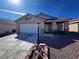 Single-story home showcasing stone accents, a two-car garage, and desert landscaping at 5513 Oakwood Ridge St, Las Vegas, NV 89130