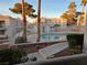 The community pool is surrounded by lush landscaping, palm trees, and fencing at 6800 E Lake Mead Blvd # 1126, Las Vegas, NV 89156