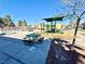 Community playground with picnic tables, slide, and climbing area, perfect for families to gather and play at 6819 Mahogany Meadows Ave, Las Vegas, NV 89122