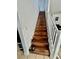 Staircase featuring wooden steps, white railings, and access to the upper level of the home at 6819 Mahogany Meadows Ave, Las Vegas, NV 89122