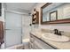 Bathroom features a shower, toilet, and vanity with granite countertop and wood-framed mirror at 6925 Donald Nelson Ave, Las Vegas, NV 89131