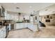 Bright kitchen features stainless steel appliances, granite counters and white cabinetry with view to living room at 6925 Donald Nelson Ave, Las Vegas, NV 89131