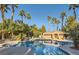 Beautiful community pool surrounded by lush landscaping and palm trees with clear blue skies above at 7250 Diamond Canyon Ln # 204, Las Vegas, NV 89149