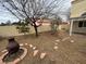 Backyard view with fire pit and seating, gravel landscaping, and a mature tree at 7509 Wheat Grass Ct, Las Vegas, NV 89129