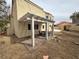 Exterior view of a home's backyard with a shaded patio and gravel landscaping at 7509 Wheat Grass Ct, Las Vegas, NV 89129