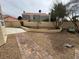 Gravel backyard featuring a patio and concrete walkway near a lush garden at 7509 Wheat Grass Ct, Las Vegas, NV 89129