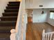 Hallway featuring plush carpet on the stairs and hardwood flooring leading to a sunlit living space at 7509 Wheat Grass Ct, Las Vegas, NV 89129