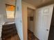 Hallway featuring tiled floors, staircase, and storage closet with door ajar at 7509 Wheat Grass Ct, Las Vegas, NV 89129