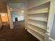 Upstairs hallway with large bookshelves connecting to carpeted rooms and a glimpse of the bathroom at 7509 Wheat Grass Ct, Las Vegas, NV 89129