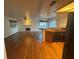 Open-concept living space with wood floors, a fireplace, and breakfast bar connecting to the kitchen at 7509 Wheat Grass Ct, Las Vegas, NV 89129