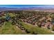 Stunning aerial view of a golf course community with red tile roofs and mountain views at 7685 Spanish Bay Dr, Las Vegas, NV 89113