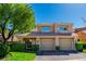 Exterior of a two-story home featuring a tile roof, a two-car garage and mature landscaping at 7685 Spanish Bay Dr, Las Vegas, NV 89113