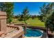 Backyard view of a pool and golf course surrounded by trees and landscaping at 7685 Spanish Bay Dr, Las Vegas, NV 89113