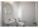 Half bathroom with white fixtures and a round mirror at 8027 Anasazi Ranch Ave, Las Vegas, NV 89131