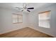 Bright bedroom with laminate floors, ceiling fan, and two shuttered windows at 8027 Anasazi Ranch Ave, Las Vegas, NV 89131