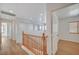 Bright hallway featuring hardwood floors, fresh white paint and a wood railing staircase at 8027 Anasazi Ranch Ave, Las Vegas, NV 89131