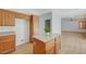 Kitchen with wood cabinets, island, and views into the adjacent room at 8027 Anasazi Ranch Ave, Las Vegas, NV 89131