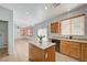 Bright kitchen features wood cabinets, island, and views into the living room at 8027 Anasazi Ranch Ave, Las Vegas, NV 89131