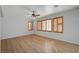 Spacious room featuring wood-look floors, natural light from shuttered windows, and a ceiling fan at 8027 Anasazi Ranch Ave, Las Vegas, NV 89131