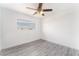 An airy bedroom featuring a ceiling fan, wood-look floors, and a window with a view at 804 Vincent Way, Las Vegas, NV 89145